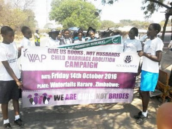Family law reform advocates hold campaign signs on International Day of the Girl Child