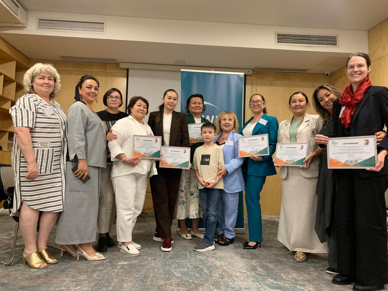 11 women in Kazakhstan showing their certificates from the SWRC leadership/climate justice training
